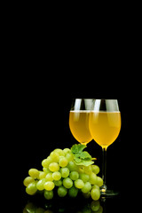 Glass of wine and grape on black background