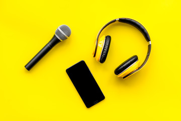 microphone, headphones, mobile for blogger, journalist or musician work on yellow background top view mockup