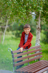boy sitting on a park bench and smiling