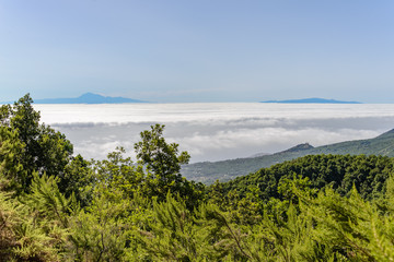 Fototapeta na wymiar A landscape looking over a sea of clouds to two distant islands. They are Tenerife and La Gomera, seen from La Palma.