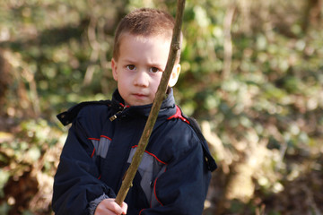 A preschooler boy in black windbreakers swings his stick  emotional portrait © kittyfly