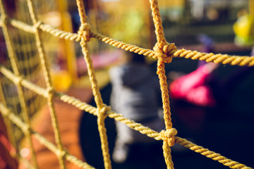 Close up on the yellow safety net at the playground against dark background