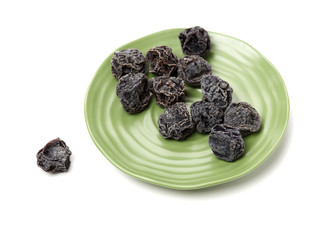 Dried black plums isolated on white background
