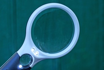 one black white plastic magnifier on a green background