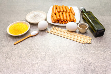 Corn dogs ingredients. Traditional American street food. On stone background.