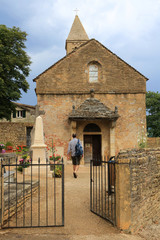 Pélerin allant à l'église. Communauté eucharistique de Taizé. / Pilgrim going to church. Parish church of Taizé. Taize Community.