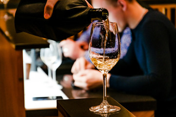 Training in school sommelier. Wine school. Wine tasting. The process of pouring wine from bottle to glass. Tinted.