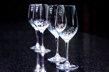 Sommelier, cavist. 4 empty wine glasses on a dark background. Wine school. Tinted.