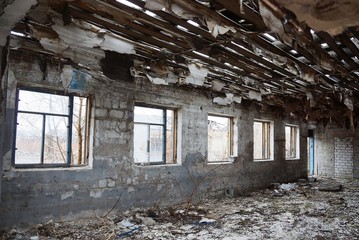 big old gray ruined room with rubbish and empty windows