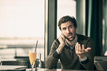 Unhappy businessman with angry face talking on the phone