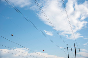 Fototapeta premium Electric poles with wires and cables set on a bright blue daylight sky.