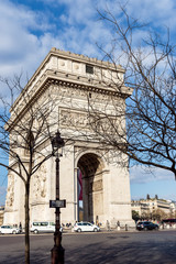Paris, France: Arc de Triomphe on Charles de Gaulle square with street lamp in foreground. Shoot in early spring.
