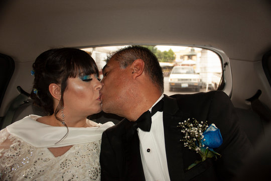 Newlyweds girlfriend and boyfriend express their love with a tender kiss after performing their wedding botos before the church in the Roman Catholic Apostolic religion in Guadalajara Mexico