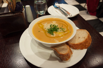 Pumpkin soup served with toasted bread, sour cream and dill