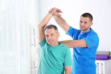 Obraz premium Doctor working with patient in hospital. Rehabilitation physiotherapy