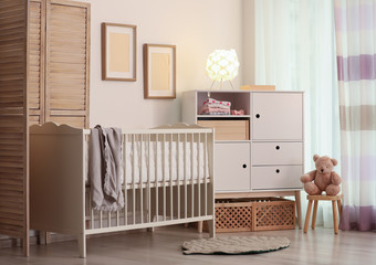 Modern room interior with crib and wooden crates under cupboard. Eco style