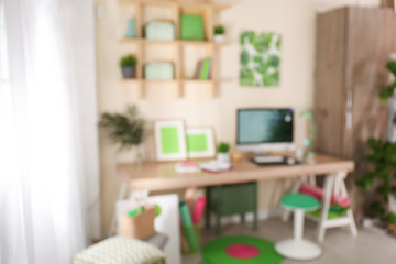 Blurred view of comfortable workplace with computer at home