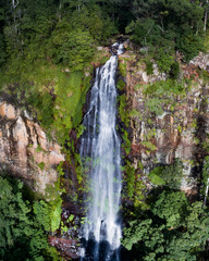 Beautiful aerial view of a waterfall at sunrise in the middle of a rainforest.  Beautiful hike, walk, adventure location in Australia, Queensland, Twin Falls circuit