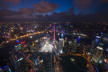 Fototapeta premium Aerial View of Shanghai Cityscape overlooking the Pudong Financial District at night. Trade zone skyline and Huangpu River, Shanghai, China