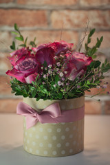 Florist at work: pretty young blond woman making fashion modern bouquet of different flowers