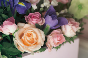 Florist at work: pretty young blond woman making fashion modern bouquet of different flowers