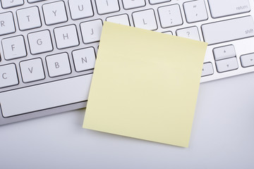 Yellow memo on white keyboard