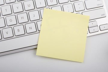 Yellow memo on white keyboard