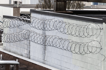 Coils of razor wire along wall