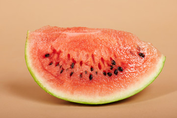 Watermelon slice on brown background