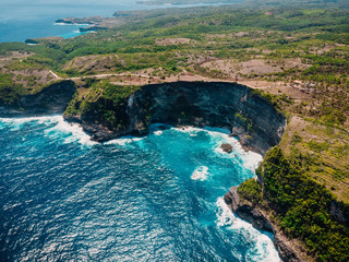 Coastline with cliff and blue ocean in Nusa Penida. Aerial drone view of tropical island