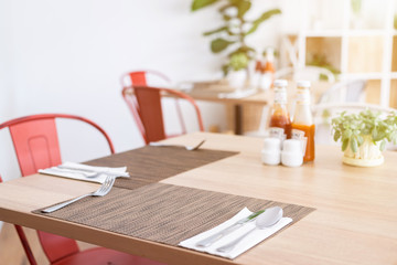 Close-up of luxurious spoon and fork, flower vaseson, sauce bottle the dining table decoration in hotel