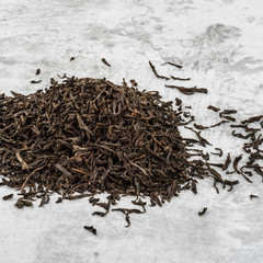 Dried tea is piled on a marble table.