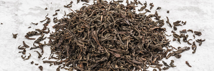 Dried tea is piled on a marble table.