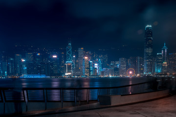 Fototapeta na wymiar Hong Kong cityscape at night. Tourists walking on the waterfront