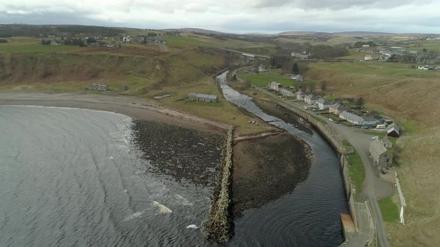 Aerial view heading inland towards Dunbeath town across the river mouth, Caithness, Scotland