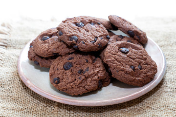Chocolate chip cookies in a plate on wood table.