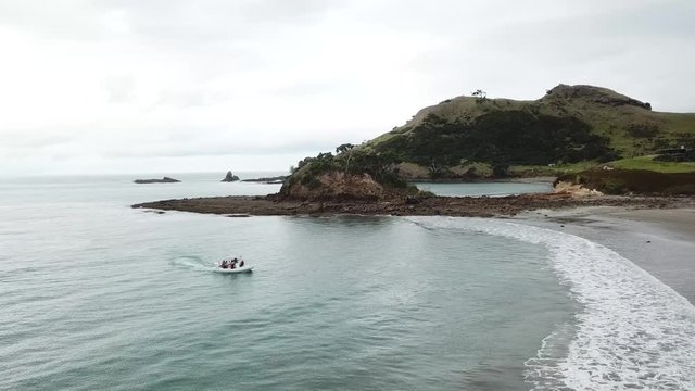 Aerial shot, tracking a sea legs from ocean onto the road, [tracking the boat on the road ROTATING] Great Barrier Island, New Zealand