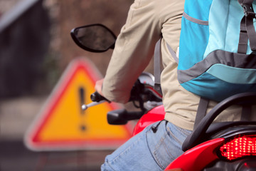 Fragment of a man on a motorcycle on the road in traffic. A cropped shot, horizontal, bokeh, blurred. The concept of traffic safety.