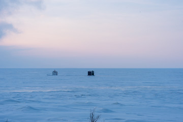 ice fishing shanty on lake at dusk