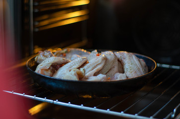 Raw chicken in the oven. Chicken wings, legs for grill