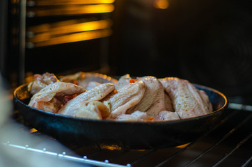 Raw chicken in the oven. Chicken wings, legs for grill