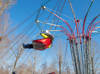 Children ride on the carousel in the park