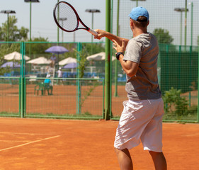 A man plays tennis on the court in the park