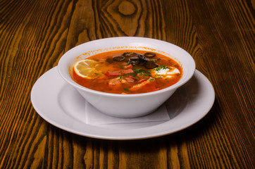 Traditional Ukrainian borsch with sour cream and white beans on a dark background. Red vegetable beetroot soup.