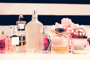 Bottles of perfume with flowers on white background