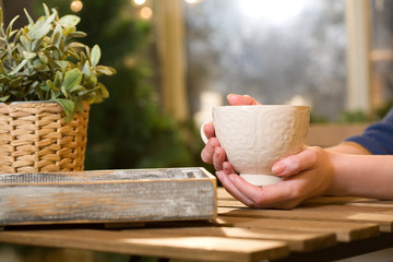 Girl sitting in outdoor cafes, drinking coffee out of big mugs. Mug in hand. Loneliness, Dating, waiting. The man didn't come out