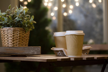 Winter. Street cafes. City, street, romantic date. Two cups of coffee, with a coffee. Coffee in a paper Cup. Wooden furniture in the cafe. Bench, vintage cafe.