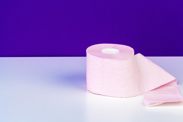 Toilet paper rolls isolated on white table with purple background