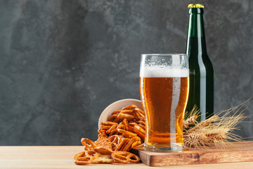 Lager beer and snacks on stone table. Cracker, chips side view