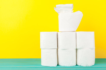 Toilet paper stacks  on bright yellow background